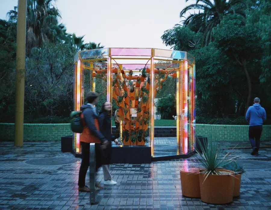 35mm photo: people walking past the sculpture