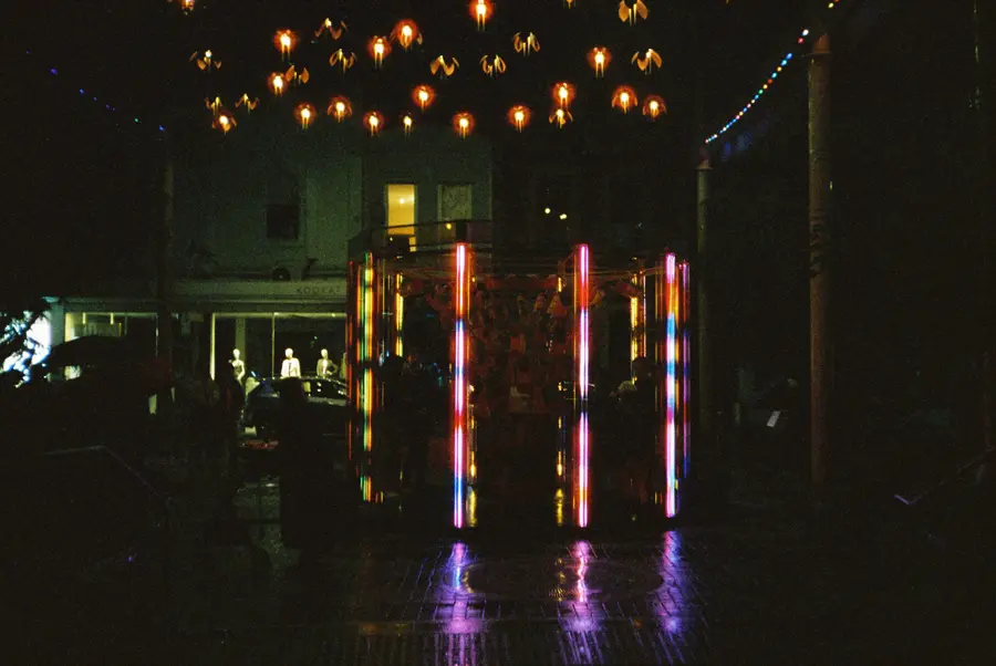 35mm photo: the sculpture at night under hanging lights